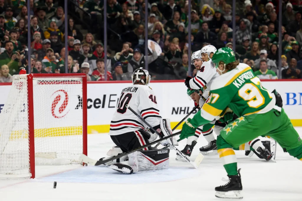 Minnesota Wild left wing Kirill Kaprizov, right, tips the puck into the net for a goal on Chicago Blackhawks goaltender Arvid Soderblom (40) during the first period of an NHL hockey game, Monday, Dec. 23, 2024, in St. Paul, Minn. (AP Photo/Ellen Schmidt)