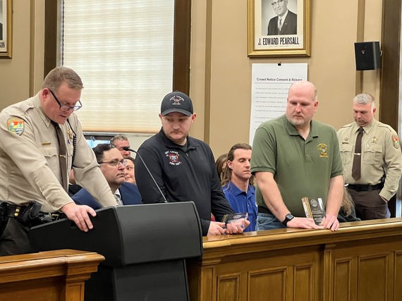 Paramedic Cody Hanson and 911 Emergency Communications Specialist Don Walters listen as Undersheriff Jason Akerson describe how they saved a man's life with CPR.