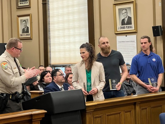 Undersheriff Jason Akerson leads a round of applause for (L-R): Lindsey Evraets, Louis Meglen, and Lucas Martin Crawford-Nichols who saved a man's life during a water emergency off Park Point.