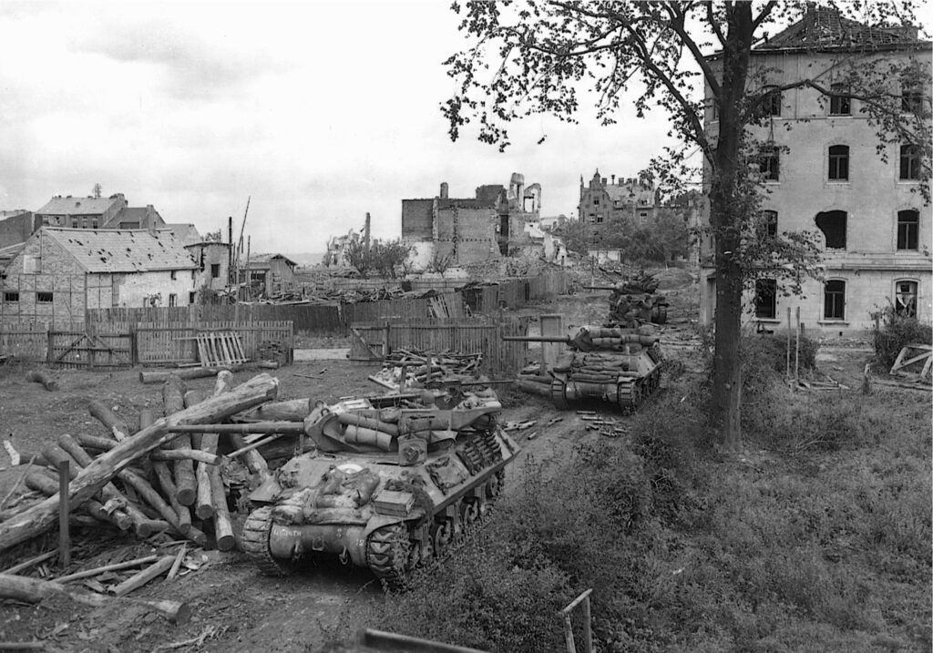 Near Aachen on October 14, 1944, open-turreted American M-10 tank destroyers fire on German observation posts in preparation for an assault and to prevent the ranging of German artillery. | National Archives